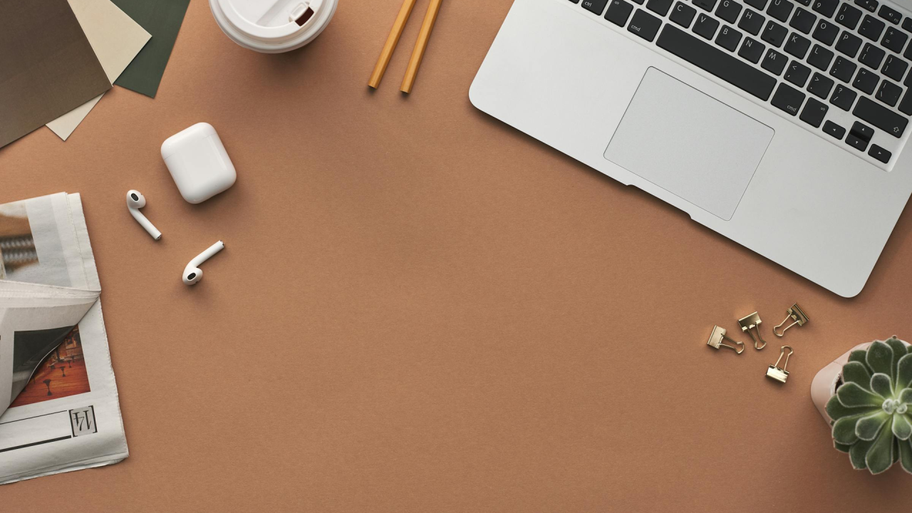 Workspace blogger con laptop, AirPods e accessori per recensioni e collaborazioni con brand