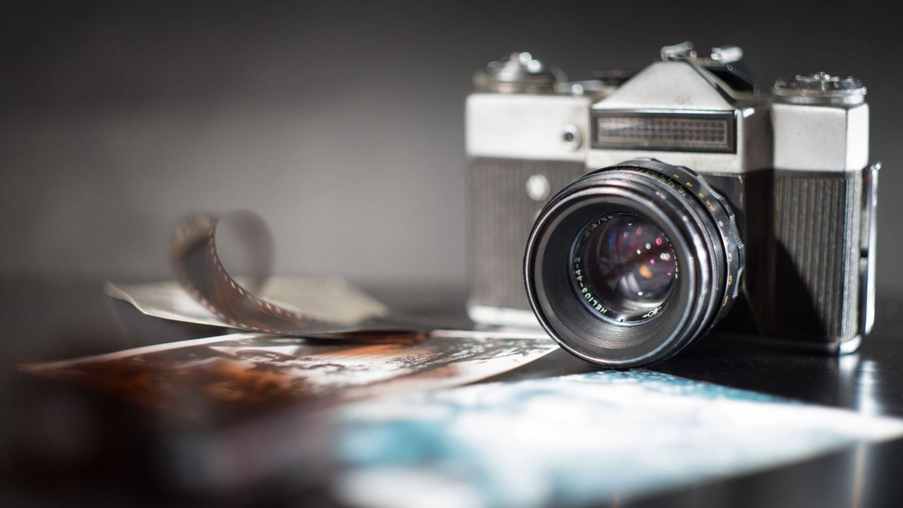Macchina fotografica vintage con rullino analogico e pellicola sviluppata