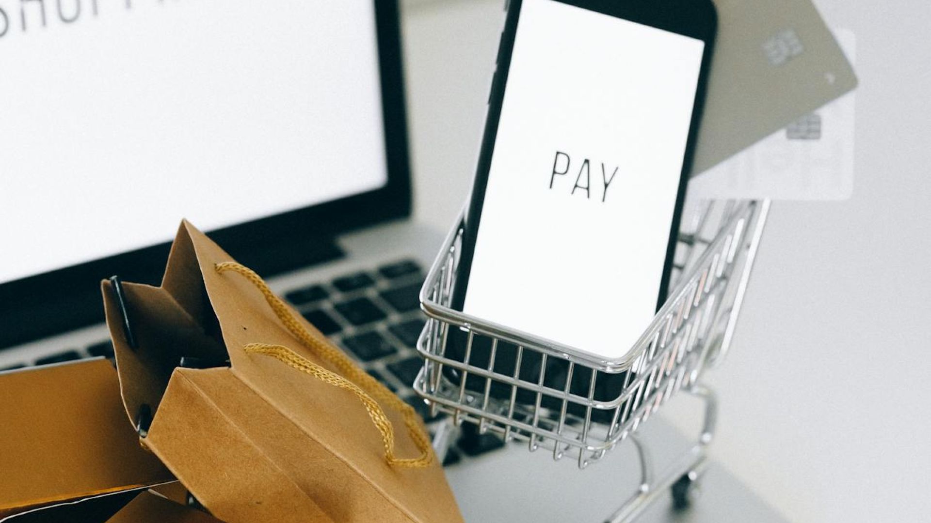Guida all'acquisto online con laptop e carrello della spesa