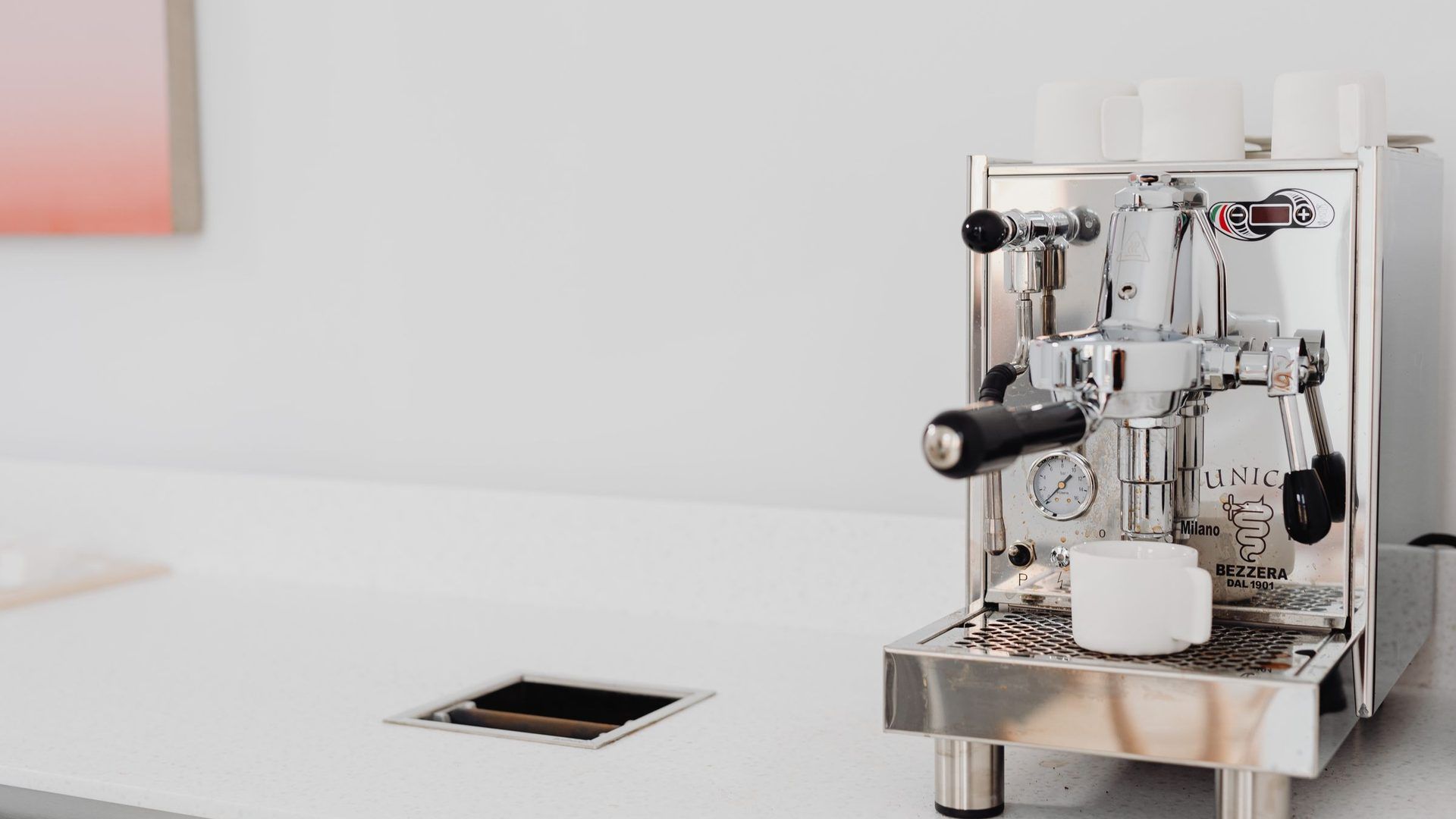 Macchina per espresso De'Longhi su piano cucina con caffè in tazzina